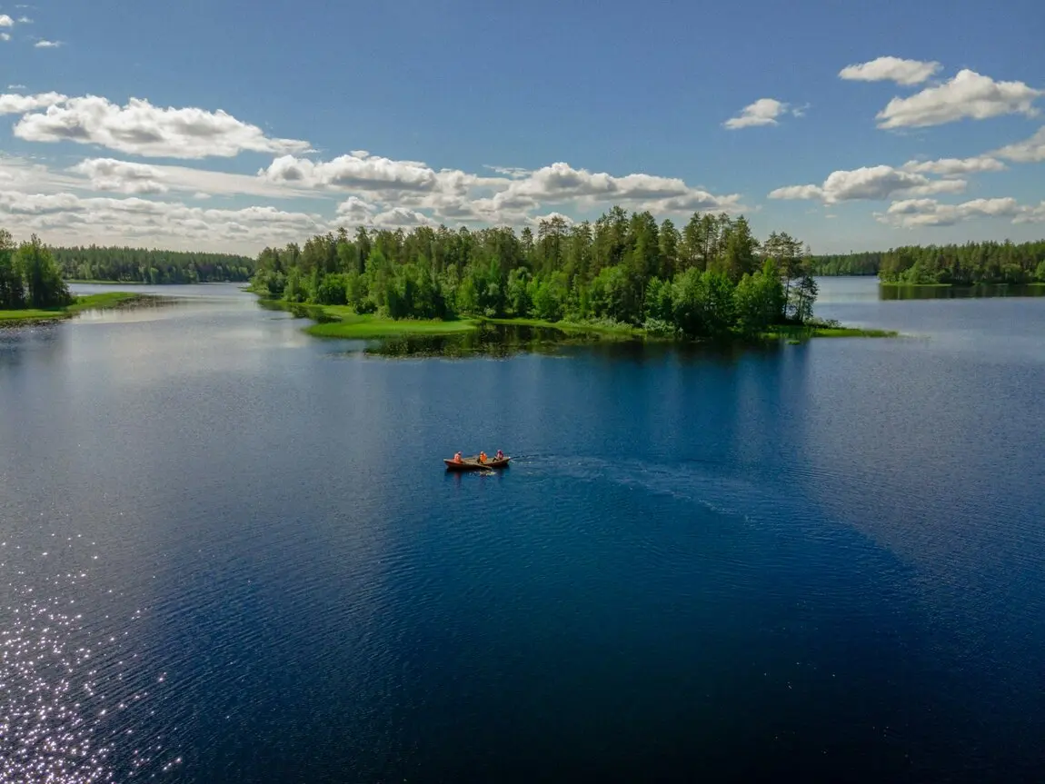 3 Leute sitzen in einem Boot auf einem See in Finnland Stell dir vor, du sitzt mit zwei Freunden in einem gemütlichen Boot auf dem glitzernden See von Lieksa, Finnland. Um euch herum die atemberaubende Natur, die Ruhe des Wassers und der Duft von frischem Holz. Während ihr entspannt paddelt, erzählt ihr euch Geschichten und lacht über alte Zeiten. Die Sonne strahlt am Himmel und die Landschaft zieht in bunten Farben vorbei – ein perfekter Moment, um den Urlaub in vollen Zügen zu genießen!